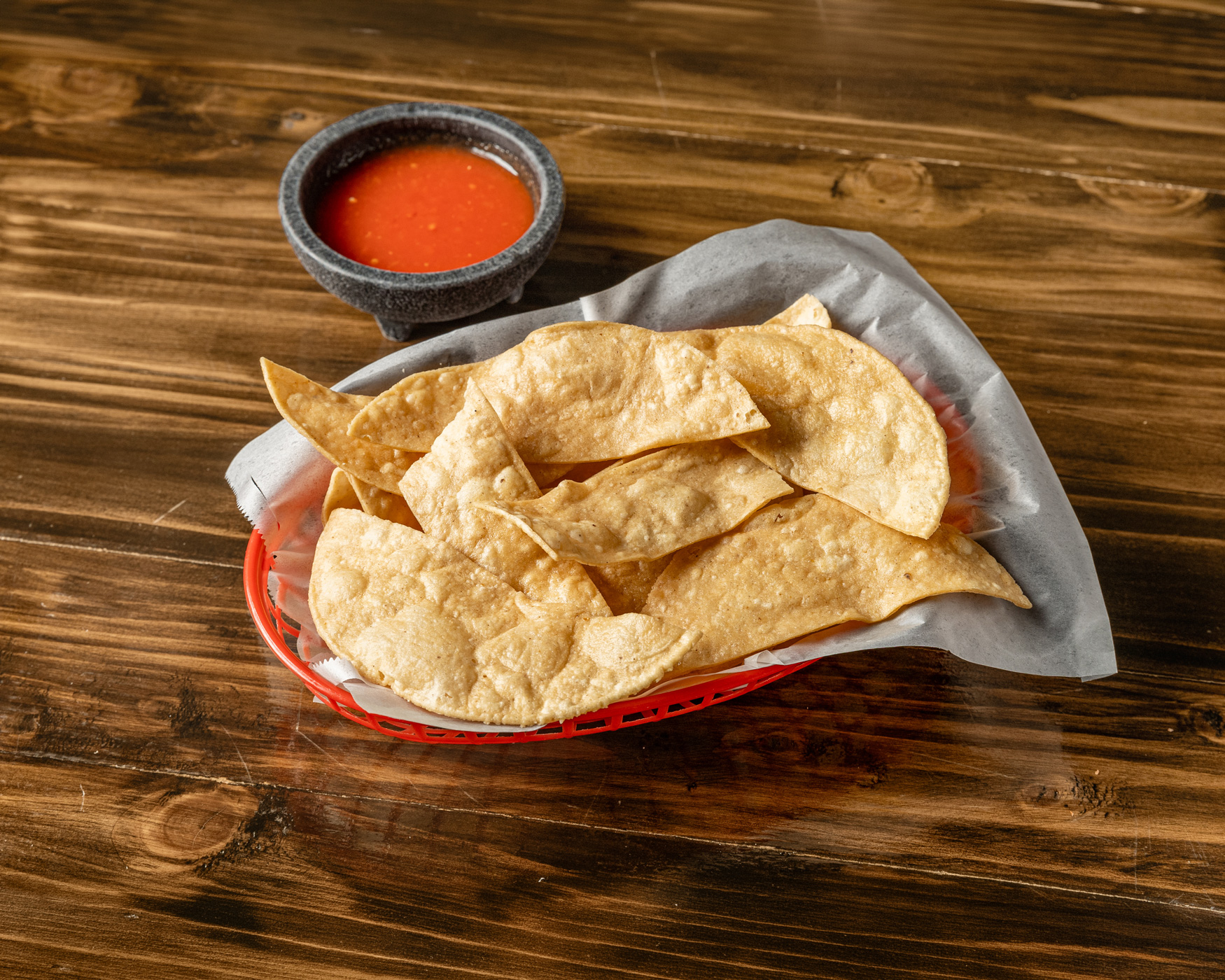 Basket of fresh-fried tortilla chips with house-made red salsa